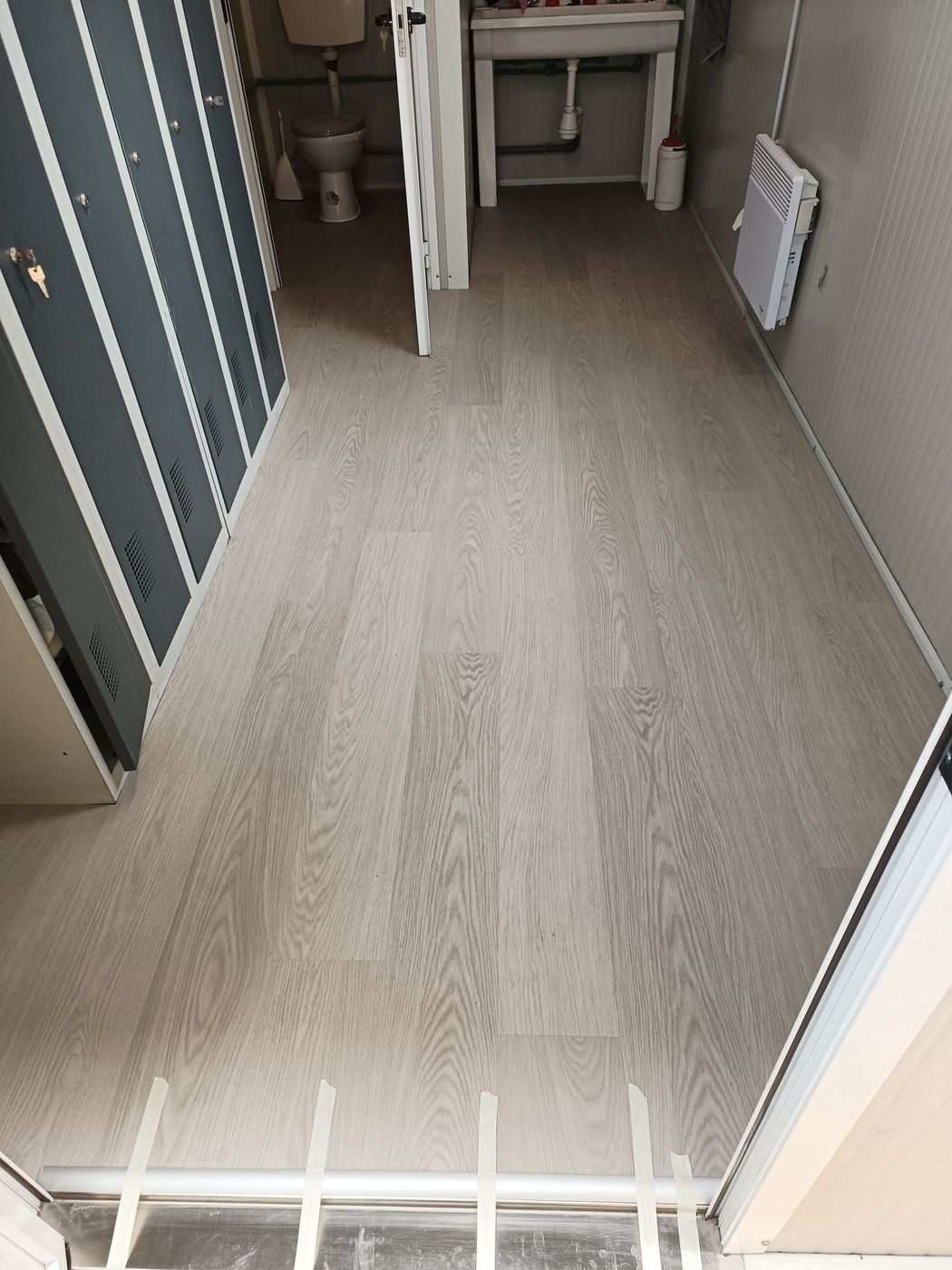 Une pièce vide avec du parquet et une fenêtre.