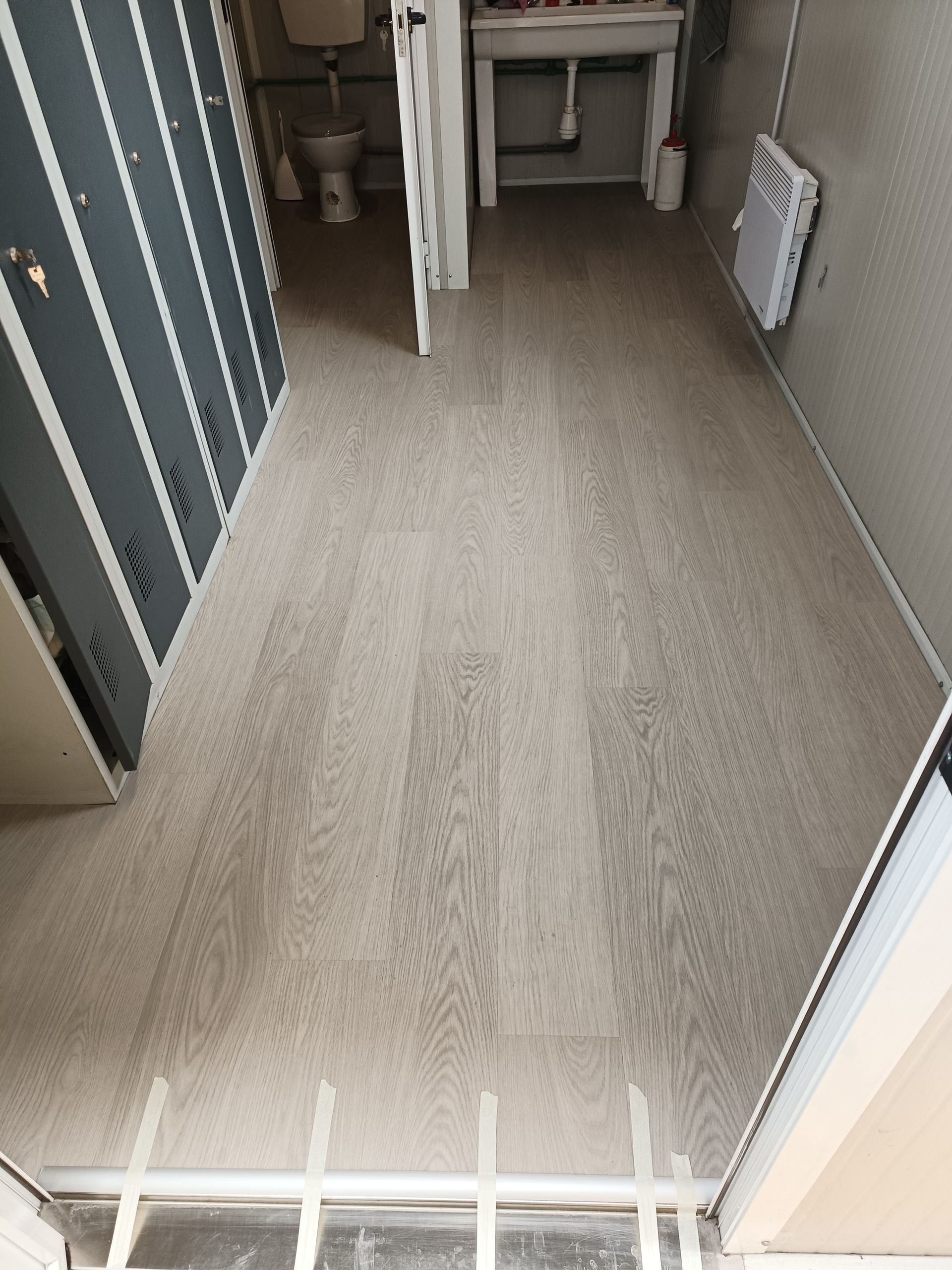 Une pièce vide avec du parquet et une fenêtre.