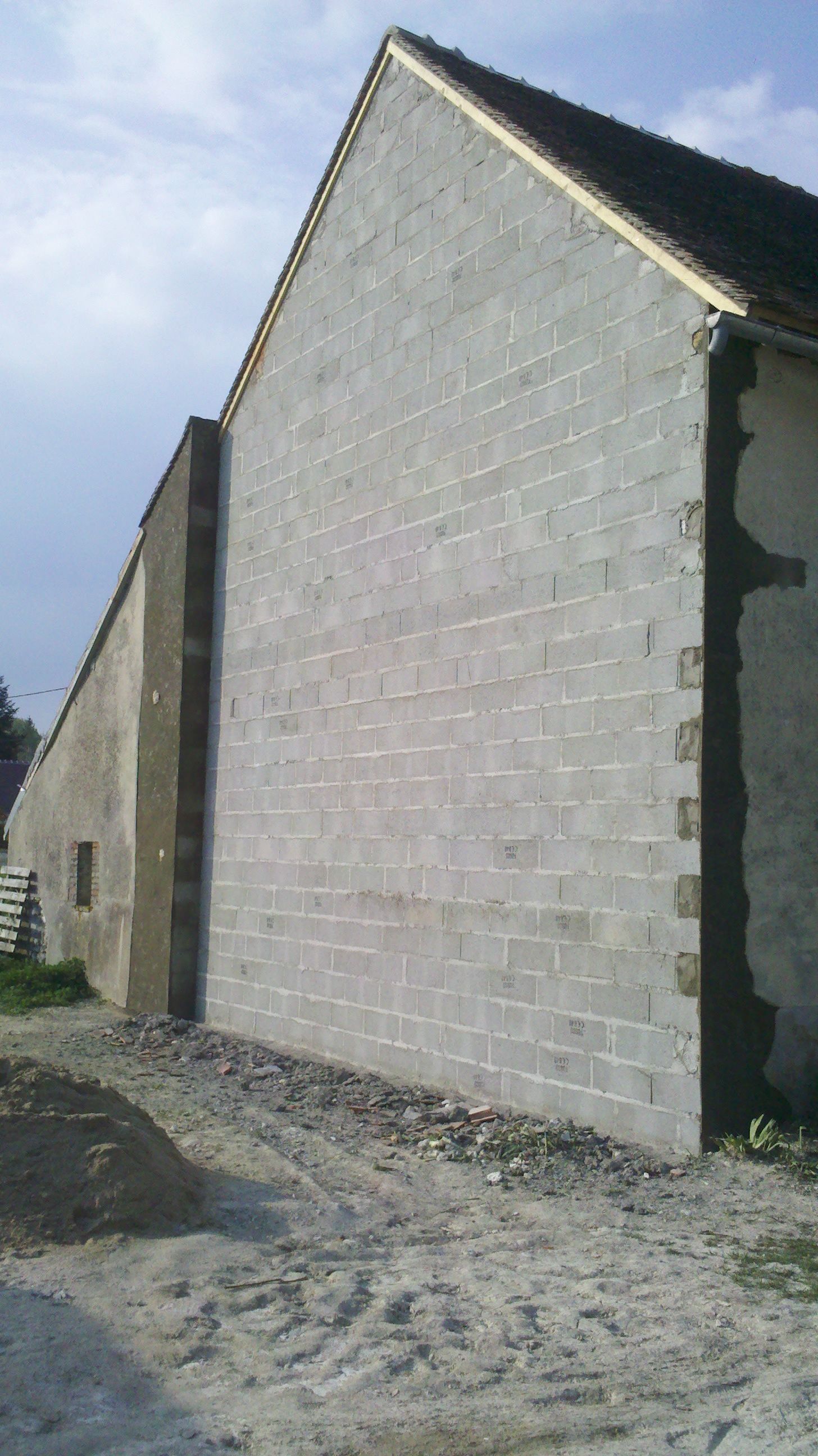 Un mur en parpaings donnant sur un chemin