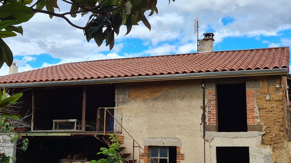Une maison en cours de rénovation ayant une toiture et des gouttières
