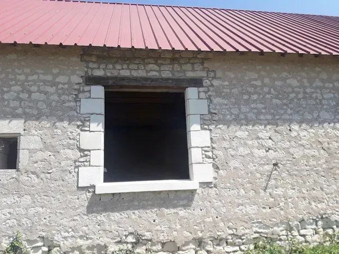 Mur d'un bâtiment en pierre avec une fenêtre.