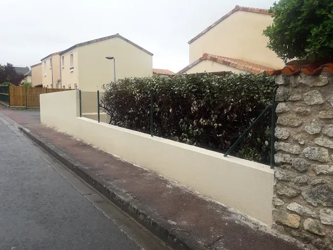 Un mur de clôture avec une haie.