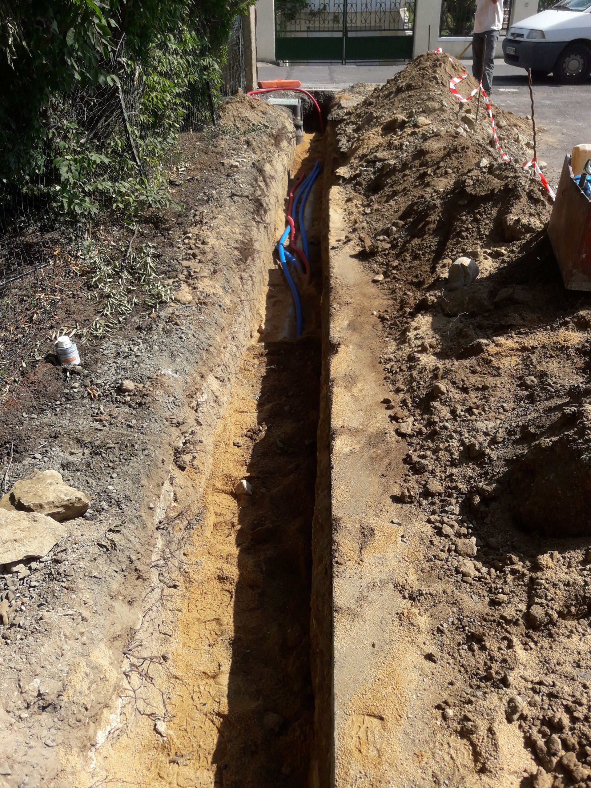 Tranchée pour les travaux de VRD avec câbles visibles