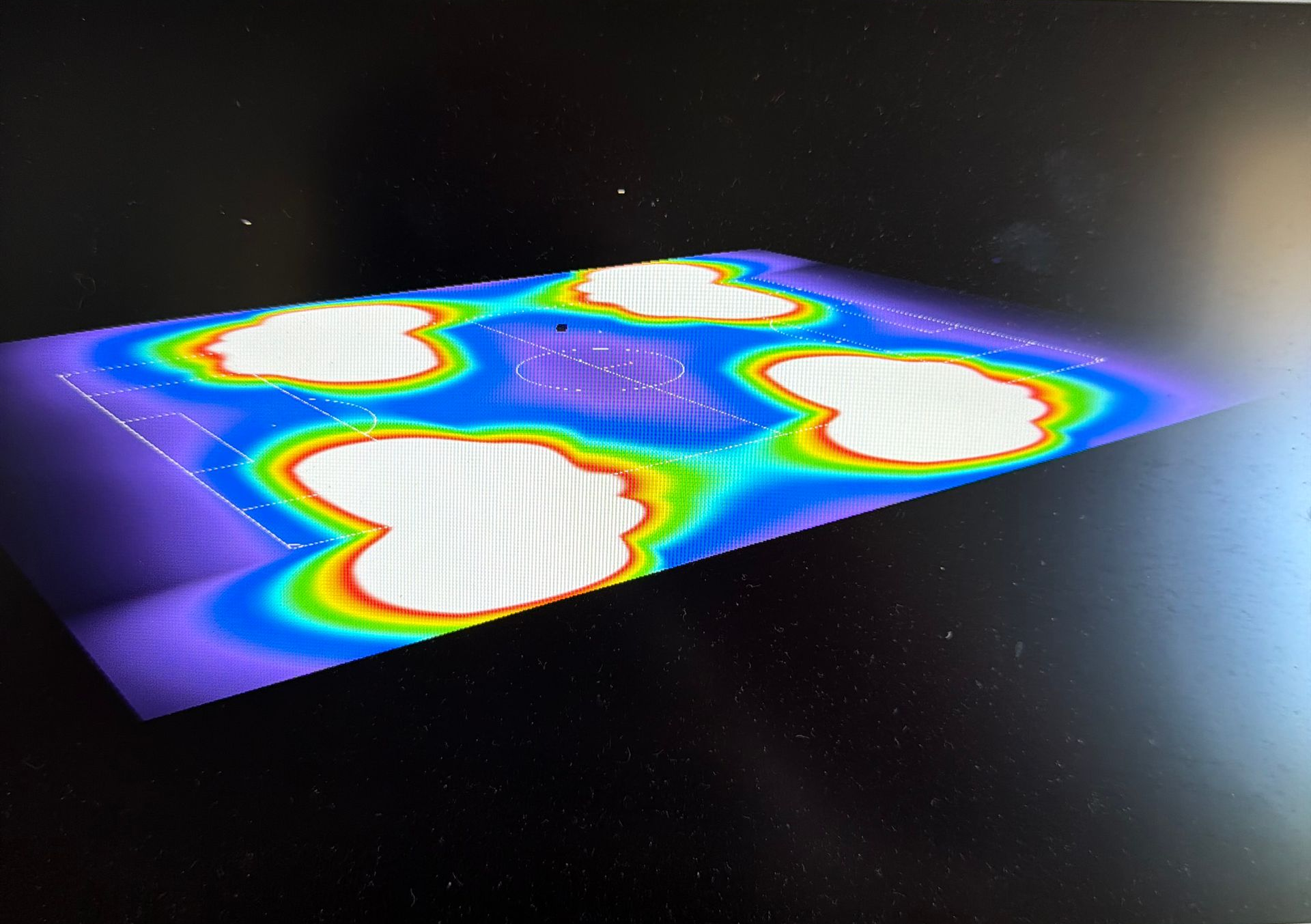 Carte thermique colorée avec quatre points chauds blancs sur une surface bleu violet, vue en biais.