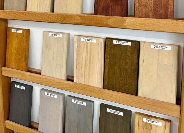 Ein hölzernes Ausstellungsregal beherbergt Reihen von rechteckigen Holzproben