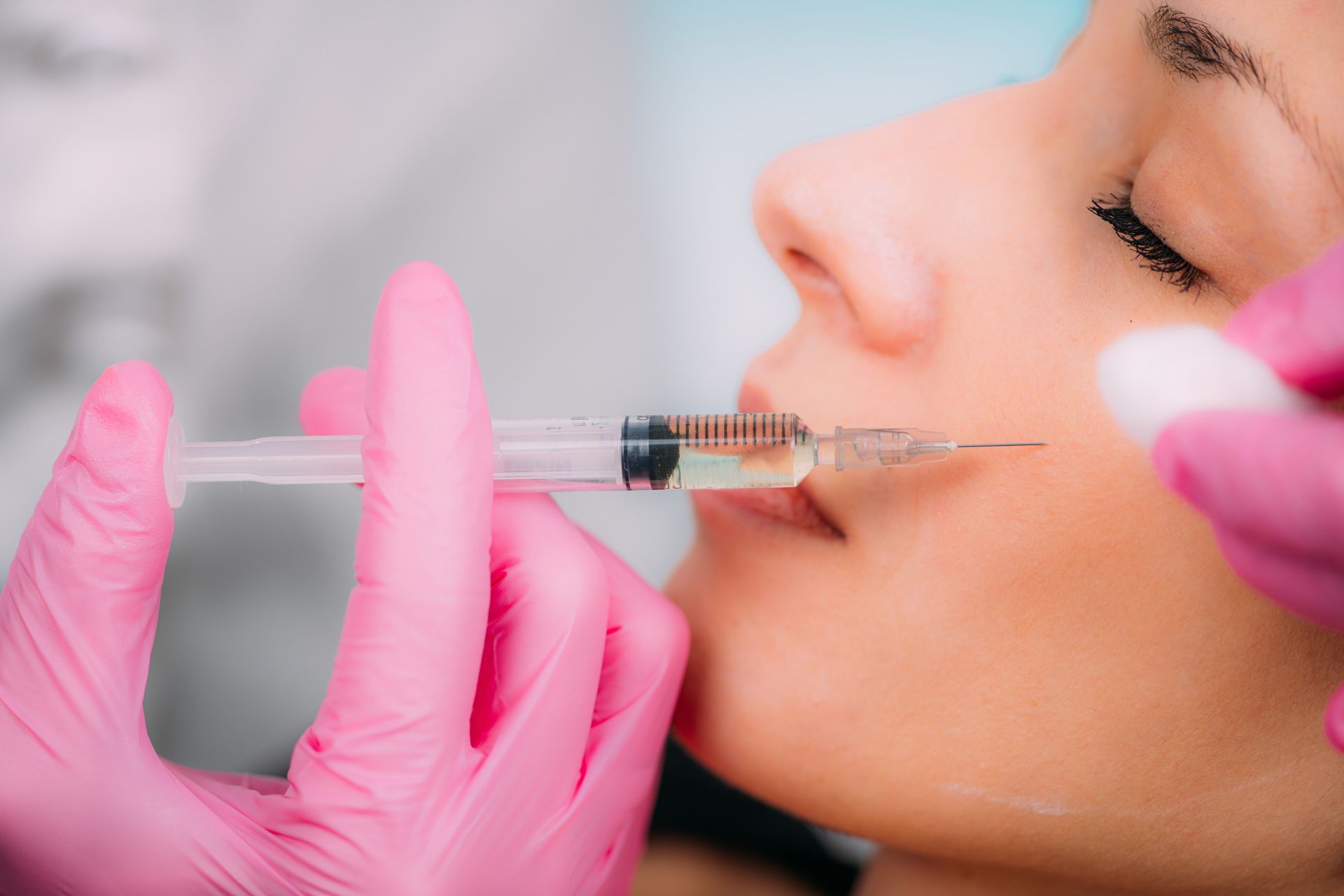 Una mujer recibe una inyección de botox en los labios.