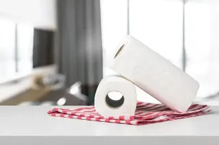 Dos rollos de toallas de papel están apilados uno encima del otro sobre una mesa.