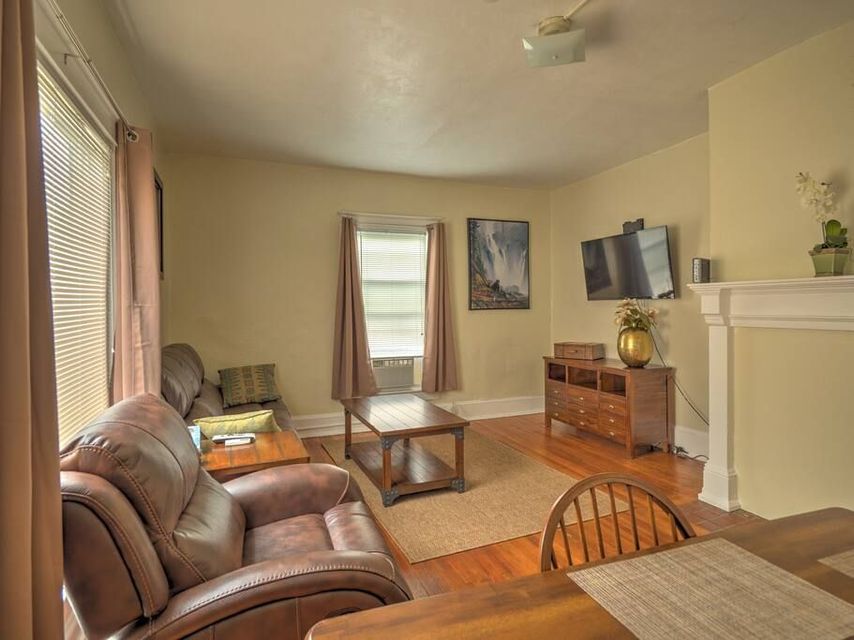 A living room with a couch , chair , table and television. 1st Base Apt 1 is available for the summer during Cooperstown All Star Weekends'.
