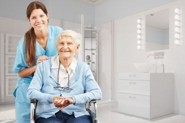 alte Person grinst und dahinter eine Pflegerin