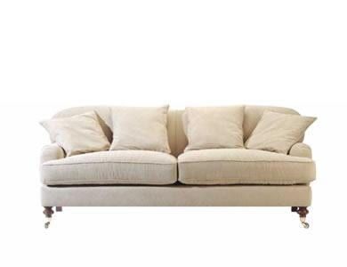 Sofá cor creme com quatro almofadas sobre fundo branco.