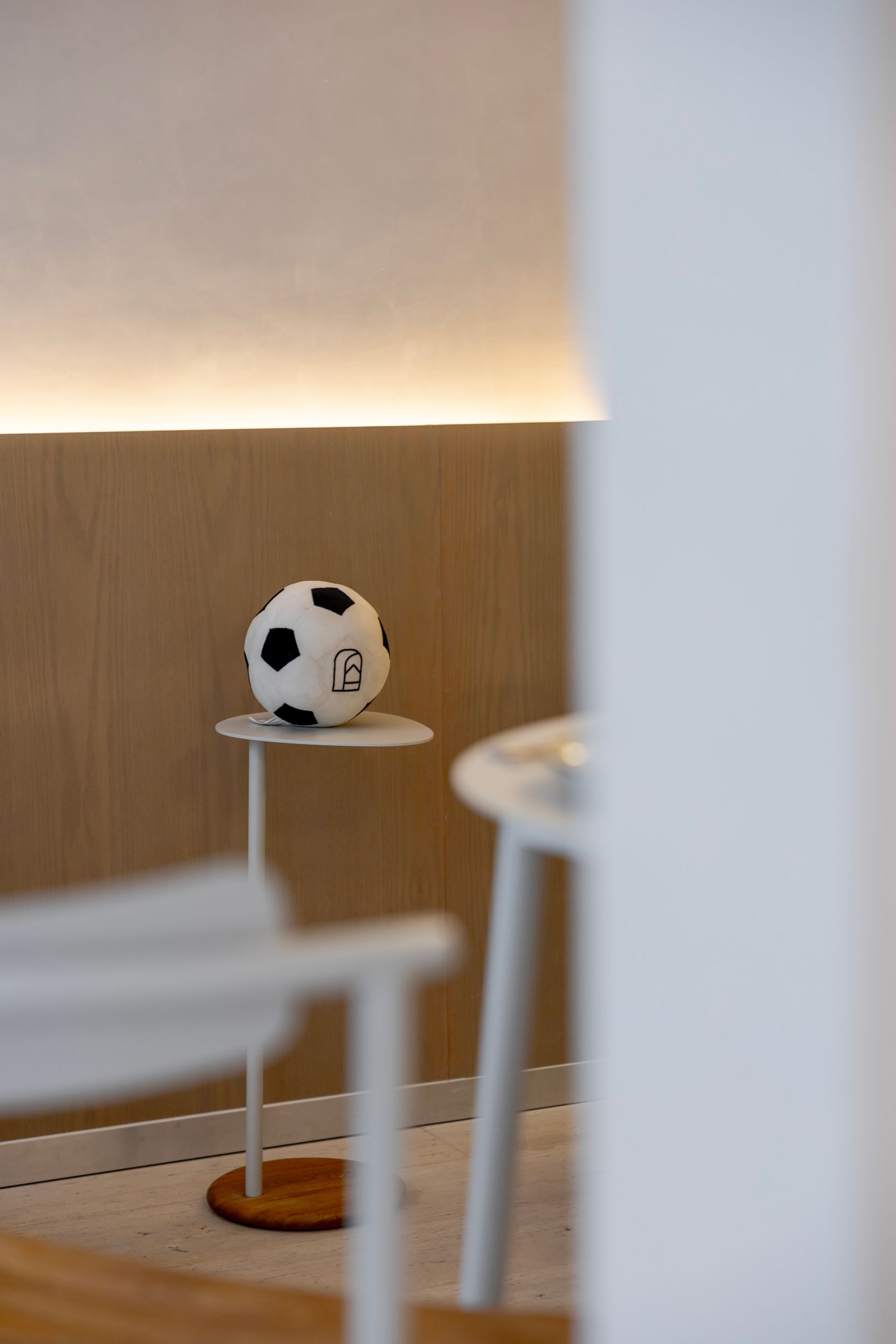 Soccer ball on a small round table in a softly lit modern room