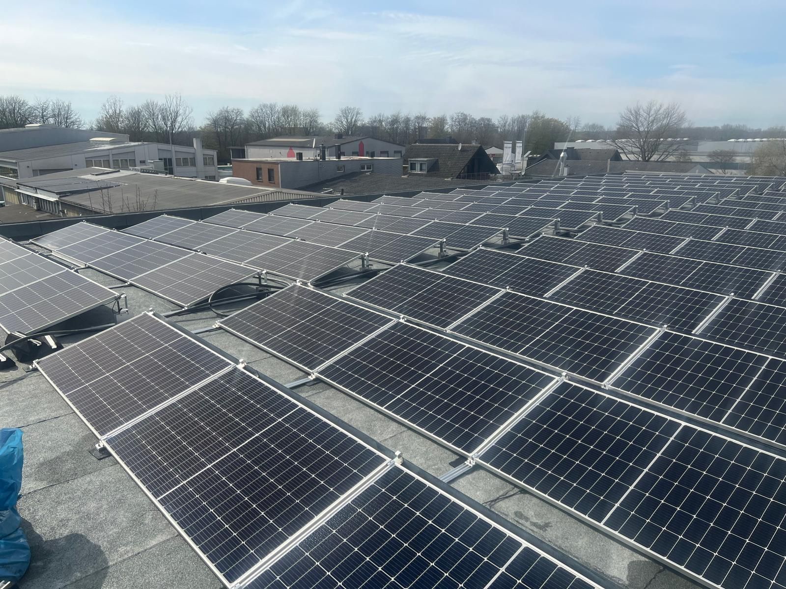 Auf dem Dach eines Gebäudes befinden sich viele Solarmodule.