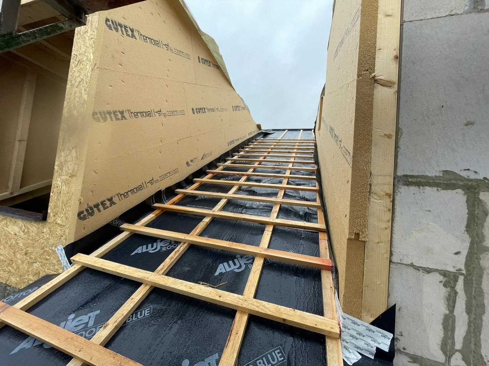 Auf einem Gebäude wird ein Dach errichtet.