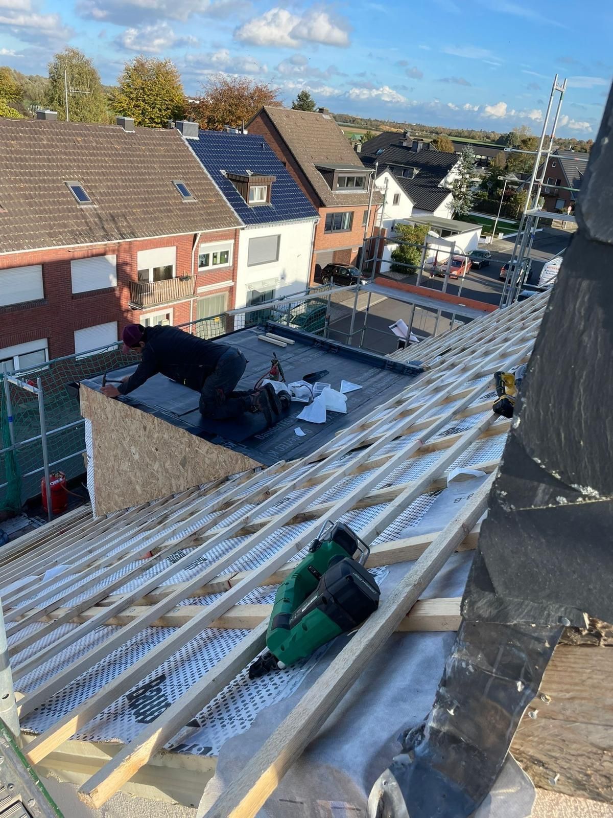 Ein Mann arbeitet auf dem Dach eines Gebäudes.