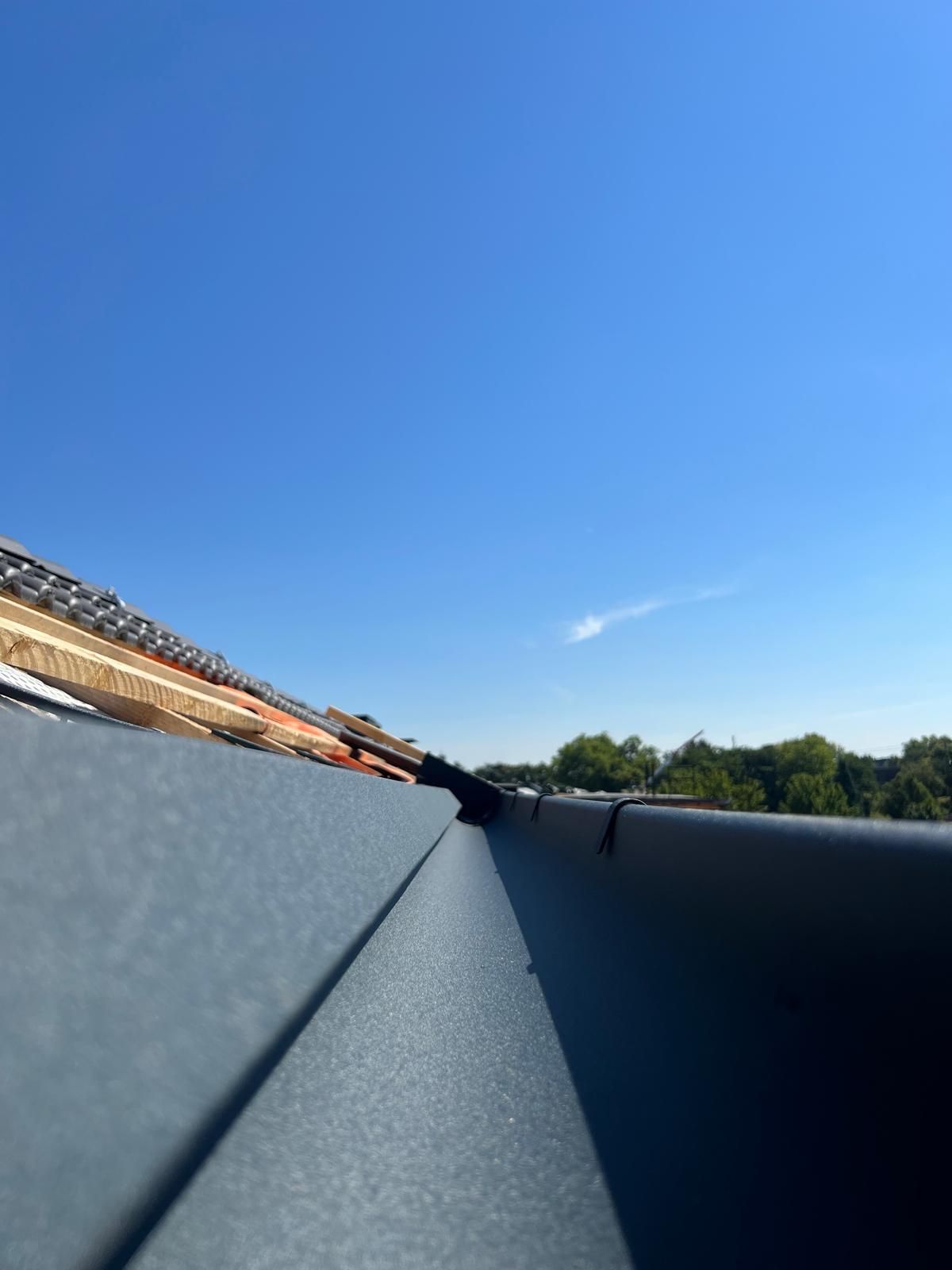 Eine Nahaufnahme einer Dachrinne mit einem blauen Himmel im Hintergrund