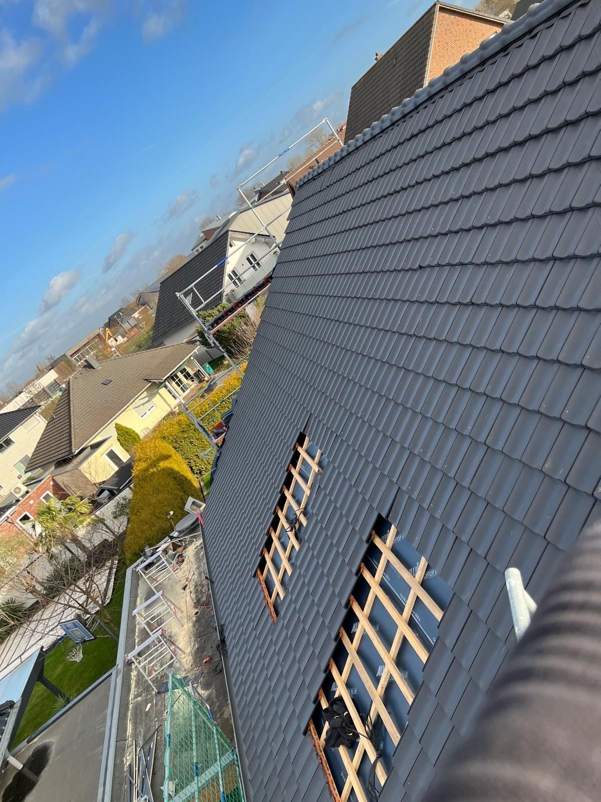 Eine Person steht auf dem Dach eines Hauses.
