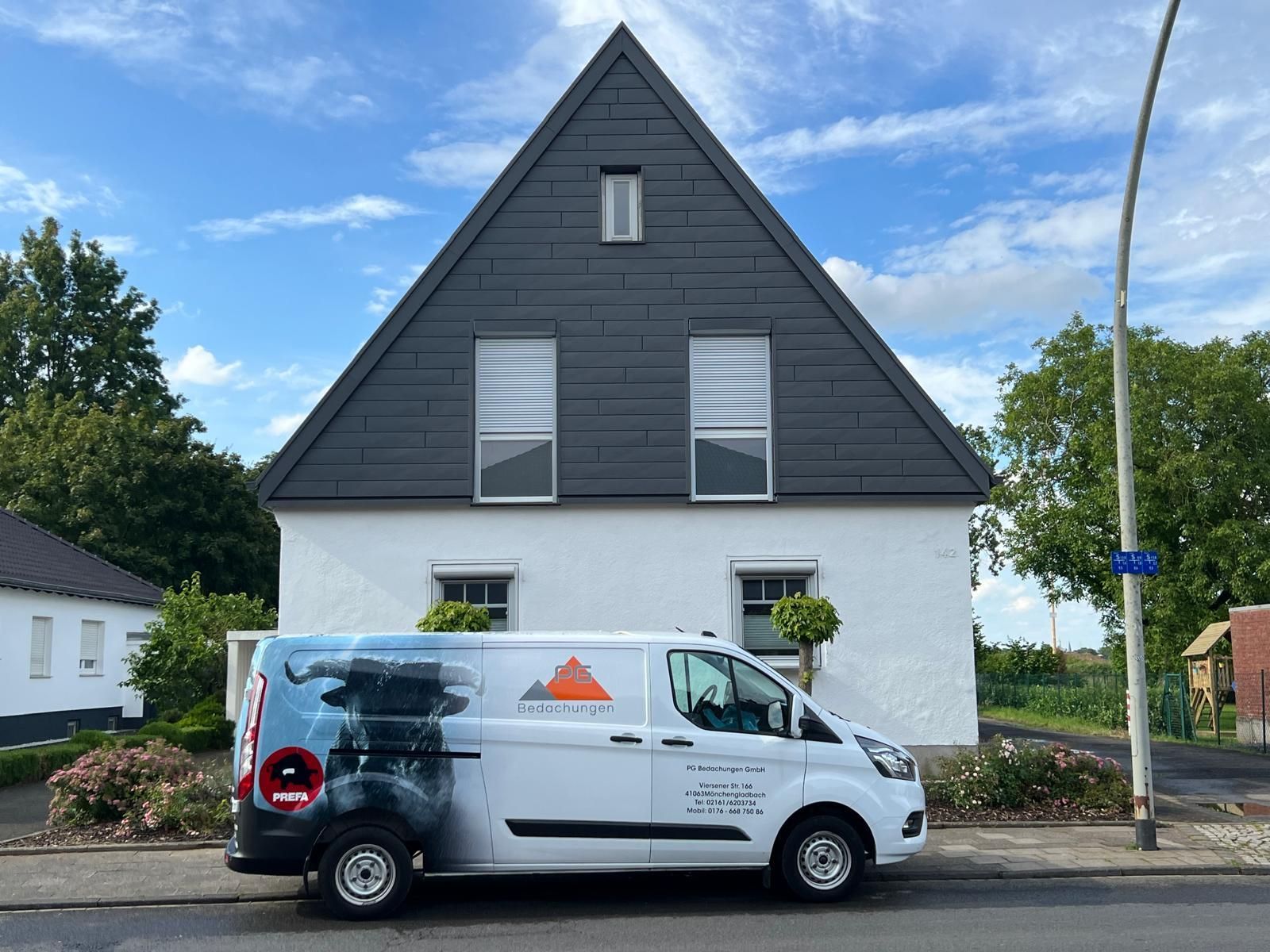 Ein weißer Lieferwagen parkt vor einem weißen Haus.