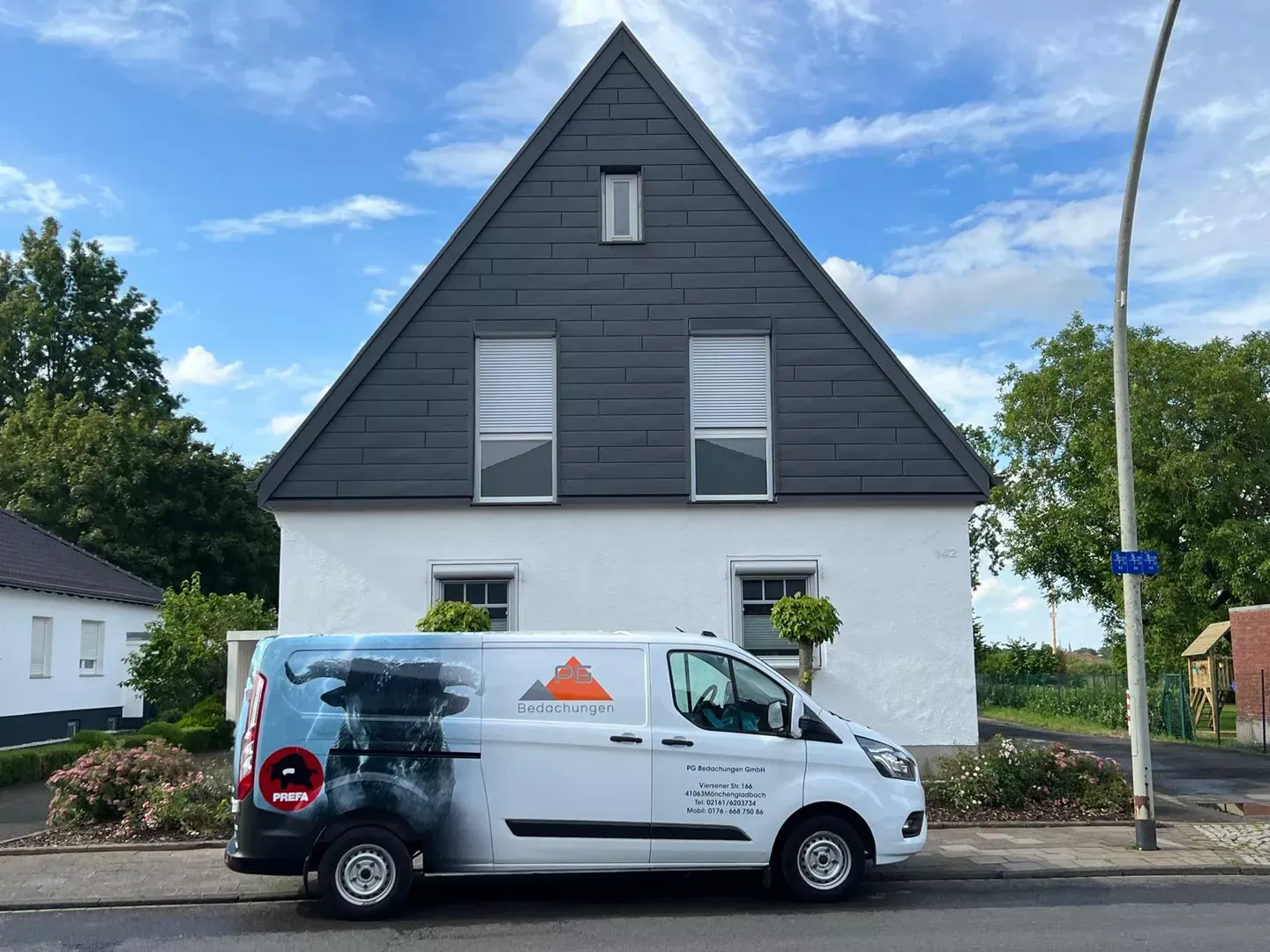 Ein weißer Lieferwagen parkt vor einem weißen Haus.
