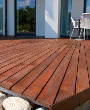 Eine Holzterrasse mit Tisch und Stühlen darauf