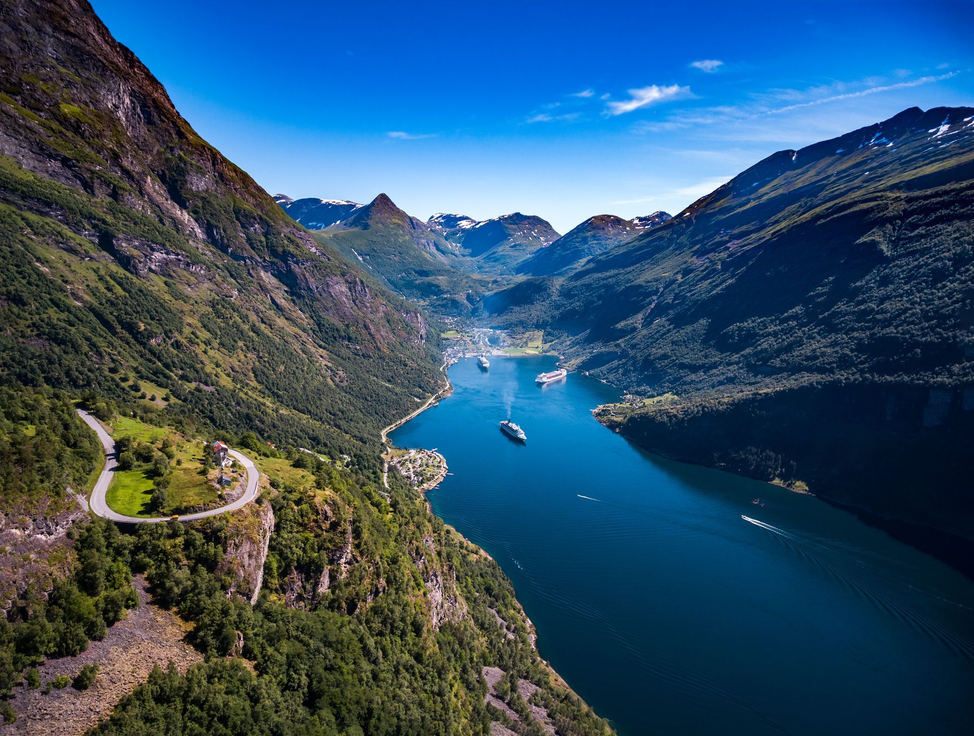 An aerial view of a lake surrounded by mountains and trees.