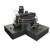 Dispositivo mecánico industrial sobre una plataforma negra con un motor y componentes curvos.