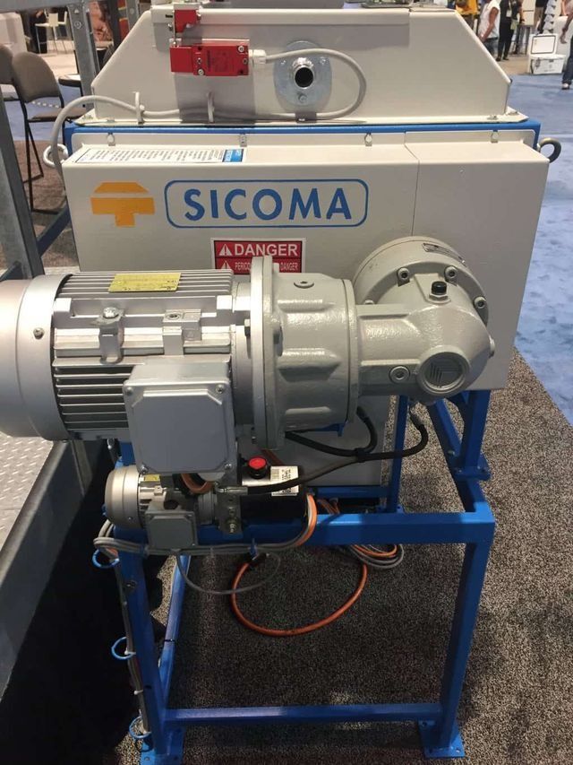 Mezcladora industrial Sicoma con motor y estructura azul en un entorno de fábrica.