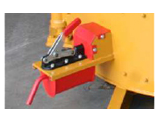 Pestillo y palanca de metal rojo en un panel lateral amarillo de la máquina.