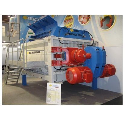 Gran exposición de maquinaria industrial con componentes azules, rojos y blancos en una sala de exposiciones.