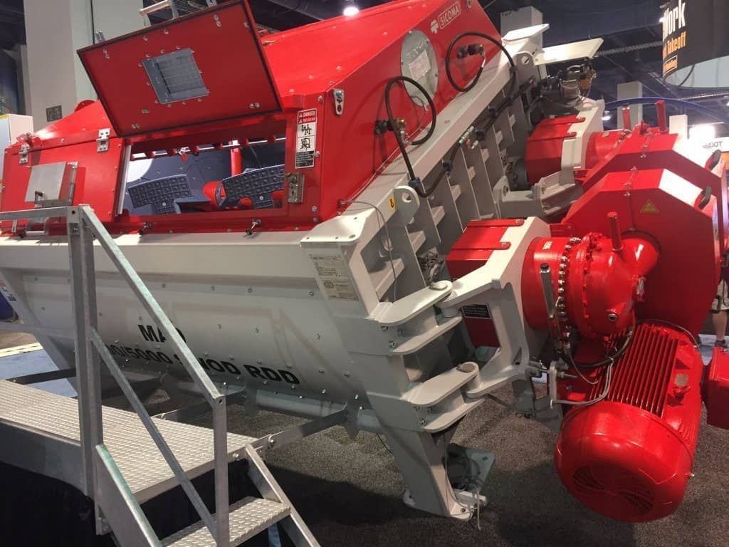 Maquinaria industrial roja y blanca con paneles abiertos y un gran motor rojo en un entorno de fábrica.