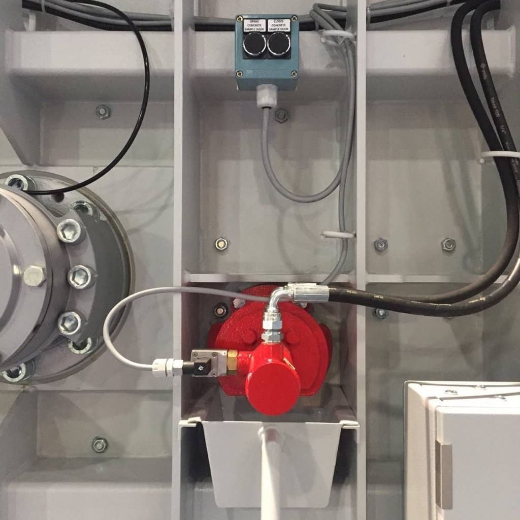 Conjunto de válvula industrial roja con mangueras y cableado dentro de un armario de control.