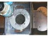 Primer plano de un componente metálico de una máquina con una abertura circular y orificios para pernos.