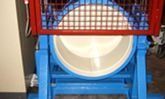 Estructura de juegos azul y roja con una abertura circular en forma de túnel blanco y red de seguridad en la parte superior.