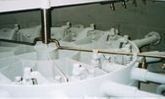 Maquinaria industrial blanca con tuberías y tolvas en un entorno de fábrica.