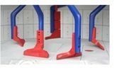 Estructuras de juegos infantiles de plástico rojo y azul, dispuestas en fila en el interior.