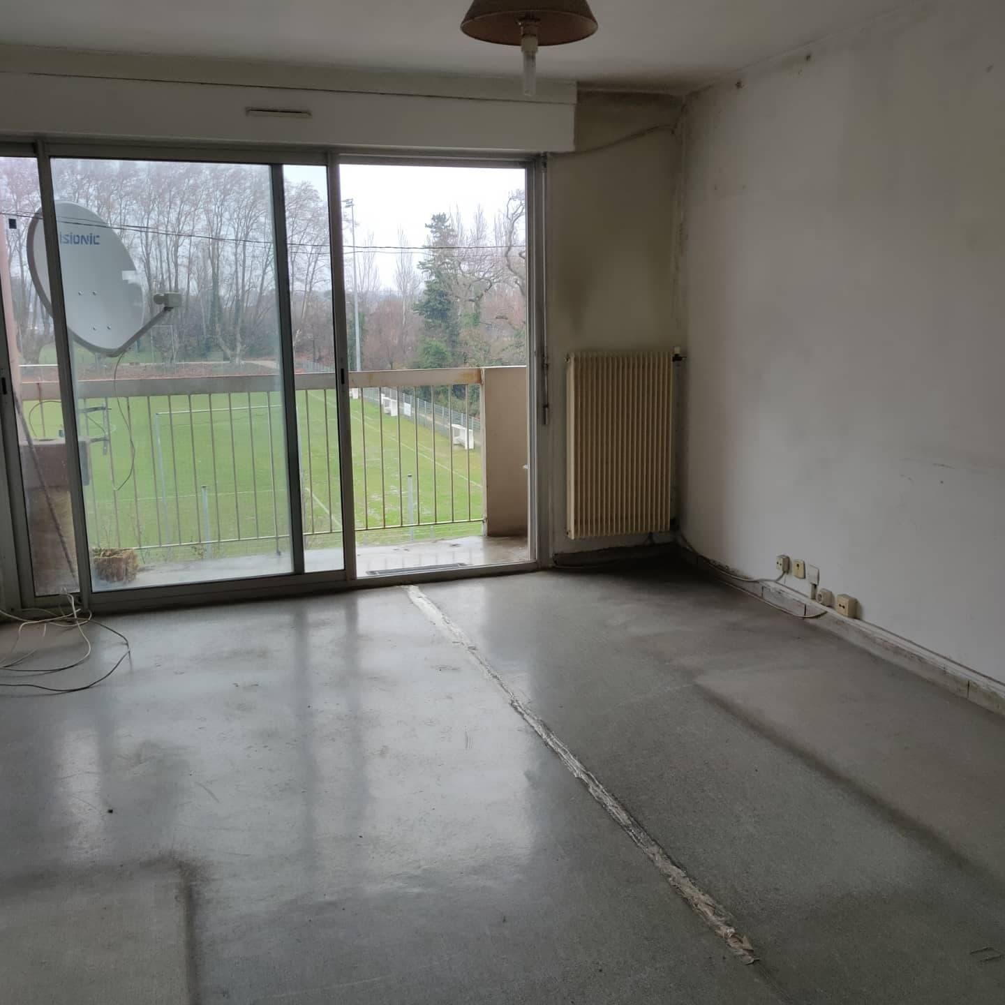 Salon débarrassé et nettoyé avec une baie vitrée