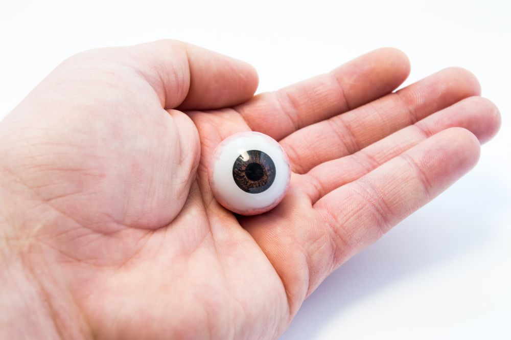 Una persona sostiene un ojo falso en su mano.