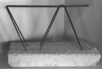 Una fotografía en blanco y negro de una estructura de metal colocada encima de un bloque de hormigón.