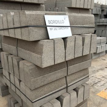 Una pila de bloques de hormigón con un cartel que dice bordillo