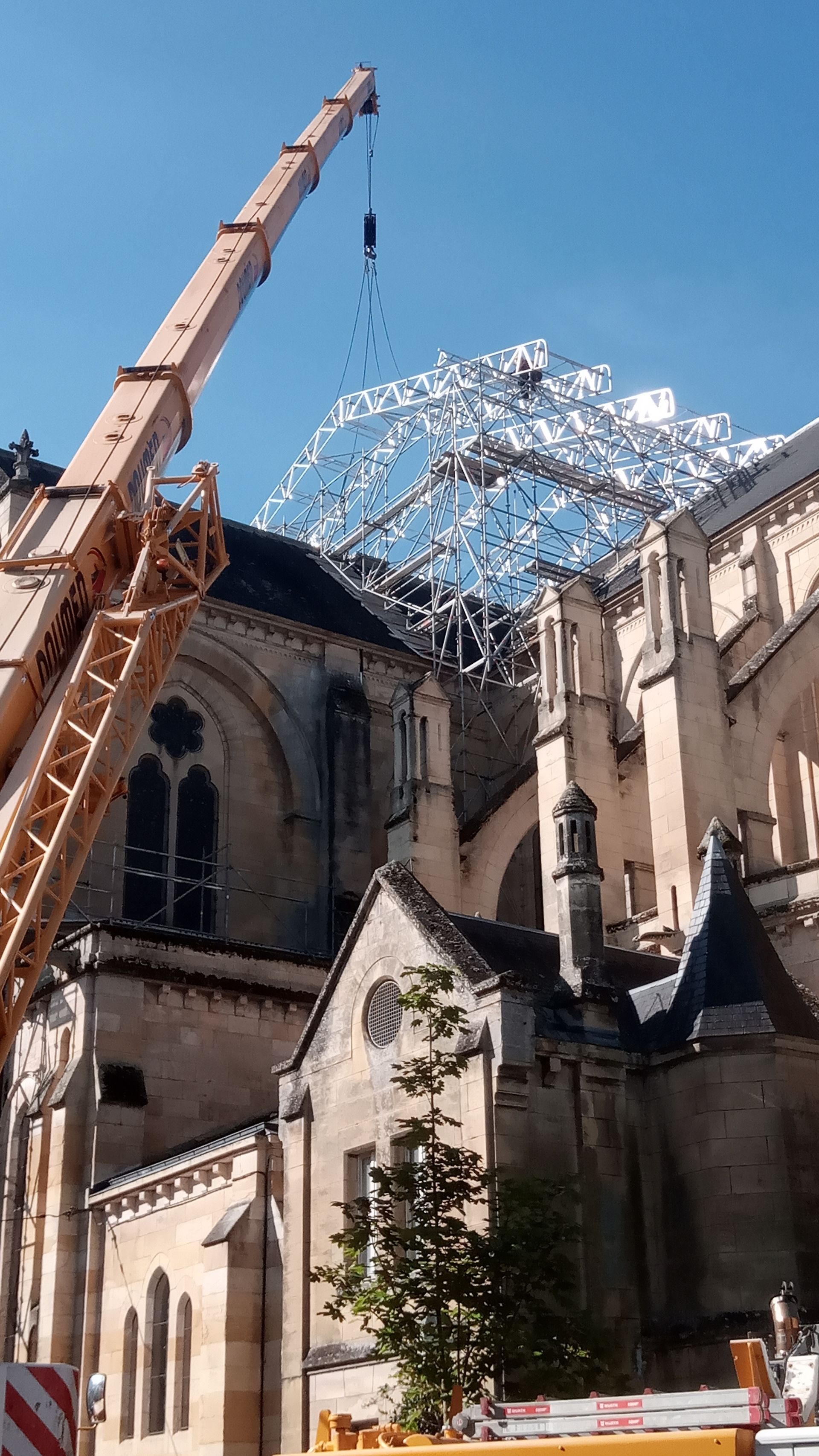 Grue à côté d'une église en train d'enlever le toit.