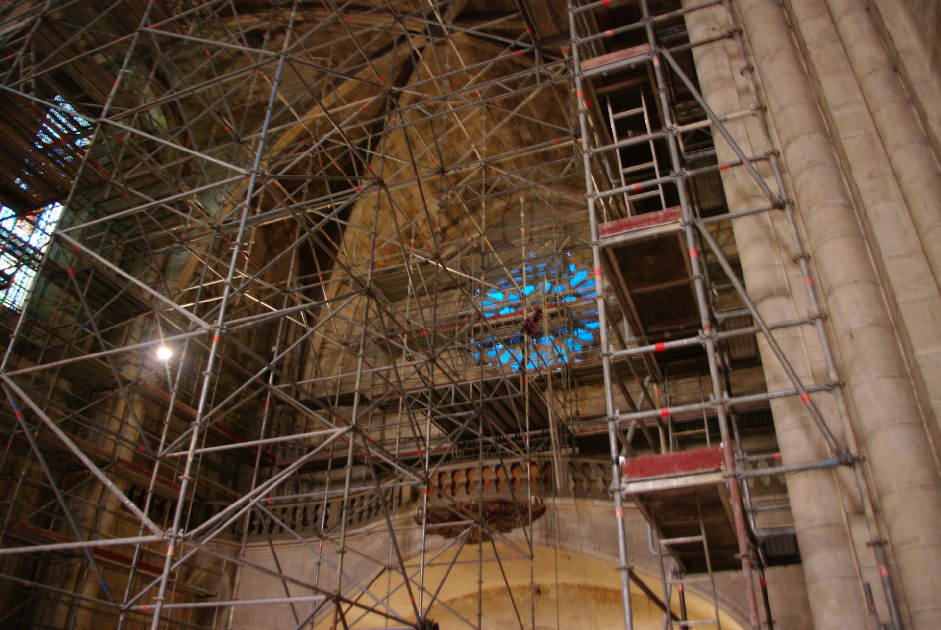 Échafaudages à l'intérieur d'un bâtiment avec un vitrail.