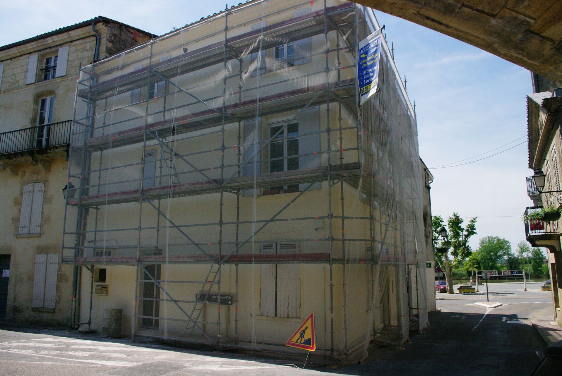 Bâtiment en rénovation, recouvert d'échafaudages et de filets de sécurité. 