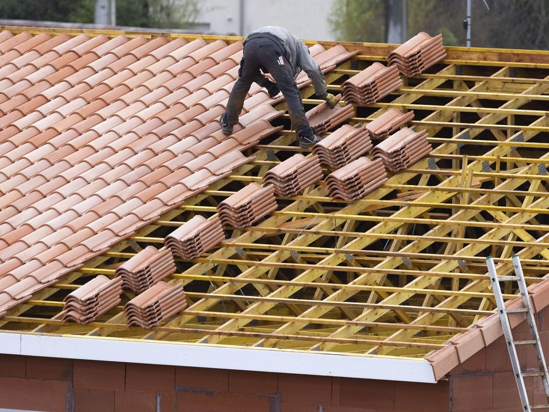 Un couvreur pose des tuiles canal