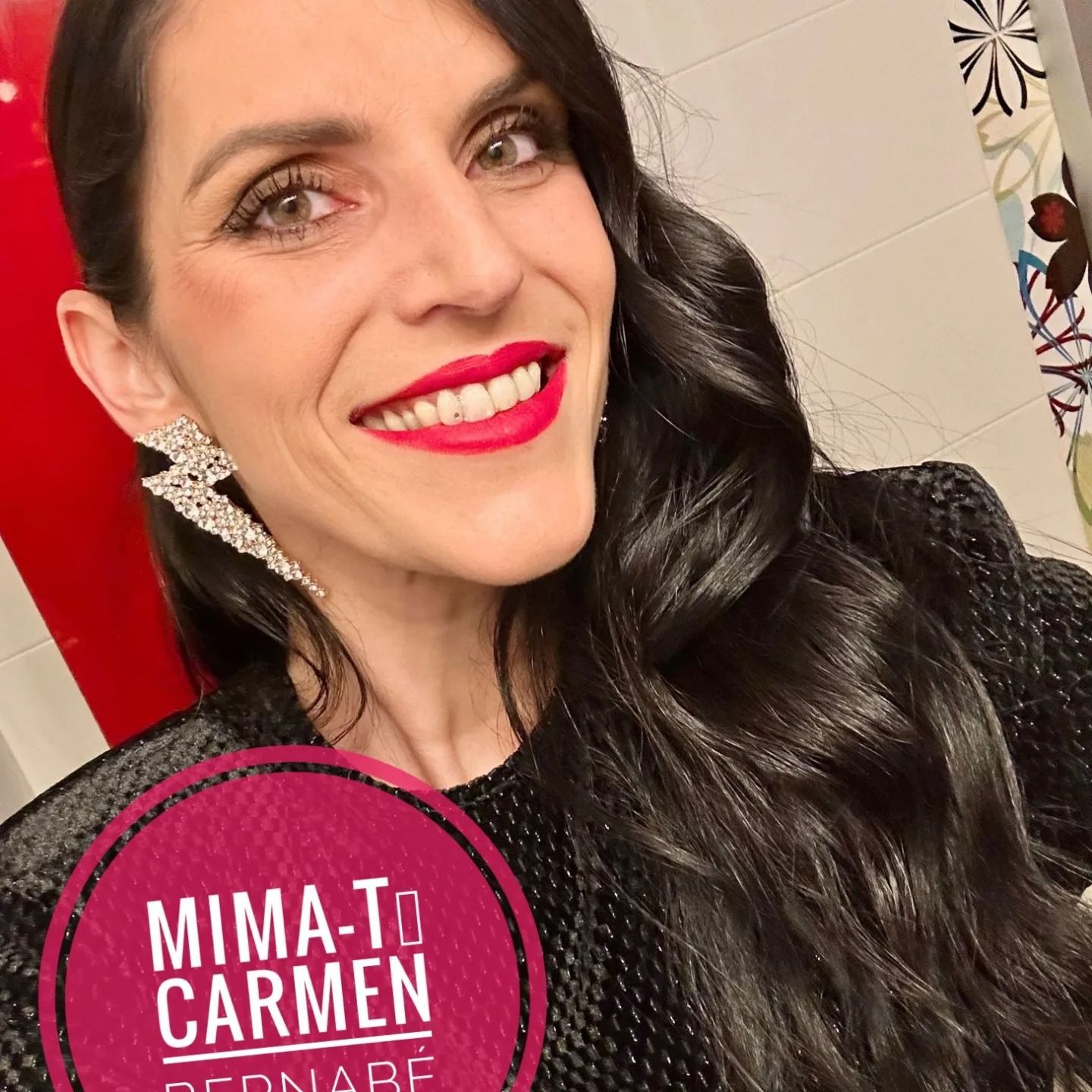 Una mujer con lápiz labial rojo y pendientes con el nombre Mima-to Carmen.