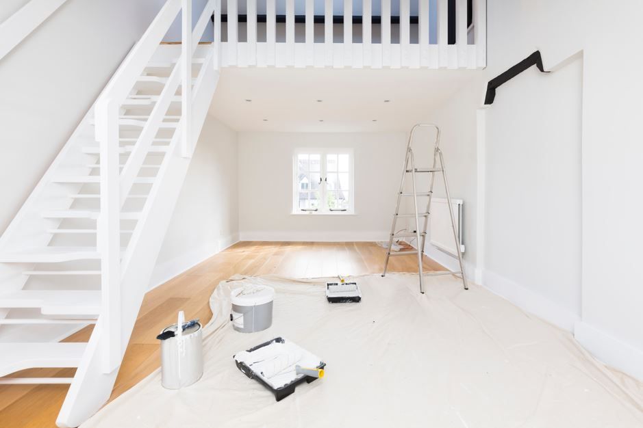 Interior luminoso, recién pintado, con loft, piso de madera y suministros de pintura.