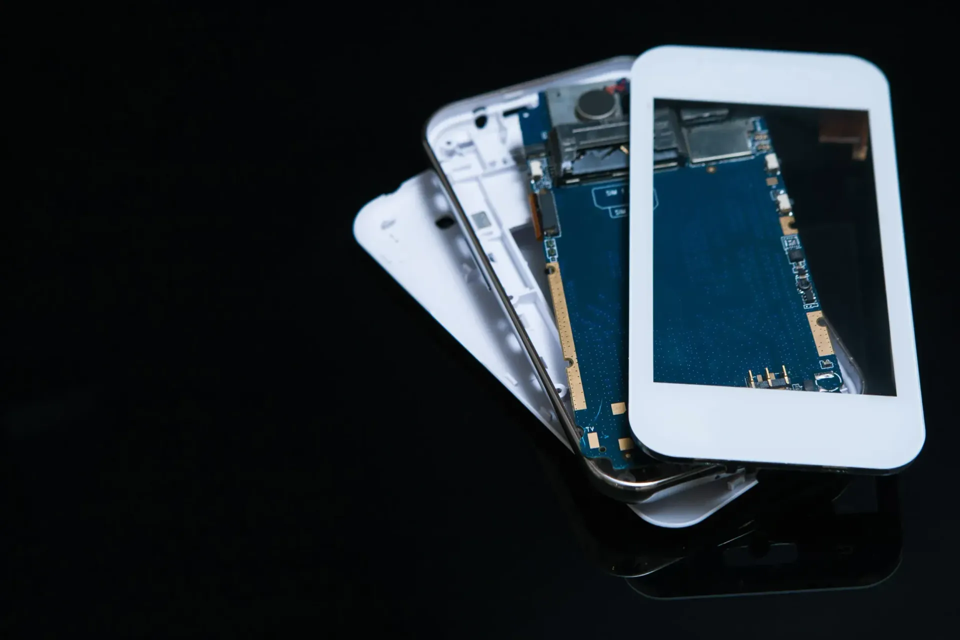 Un teléfono inteligente blanco desmontado que muestra las placas de circuitos internos azules