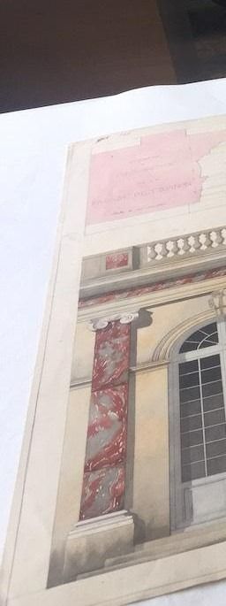 Détail architectural : une façade de bâtiment comportant une fenêtre, un pilier aux accents rouges et une balustrade.