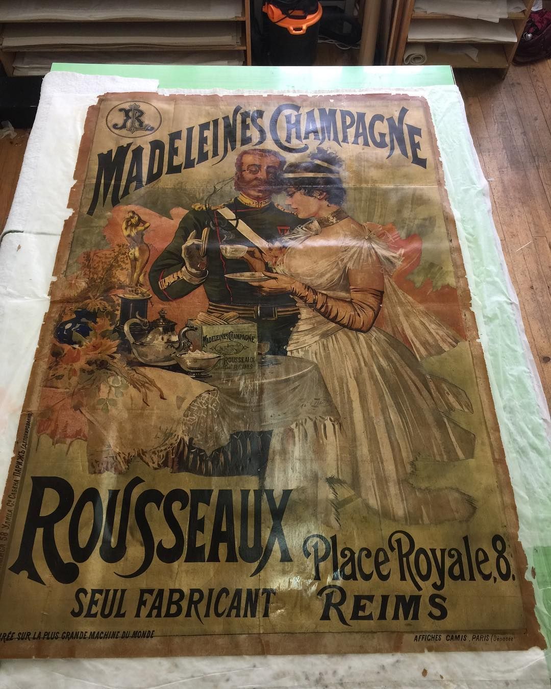 Affiche vintage de champagne : couple trinquant. Madeleines Champagne au-dessus, Rousseaux en dessous.