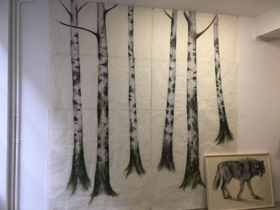 Peinture murale de bouleau sur le mur, à côté d'un dessin encadré d'un loup.