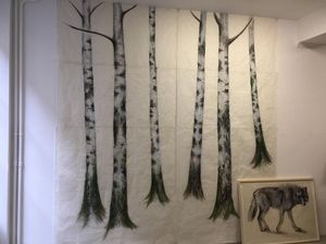 Peinture murale de bouleau sur le mur, à côté d'un dessin encadré d'un loup.