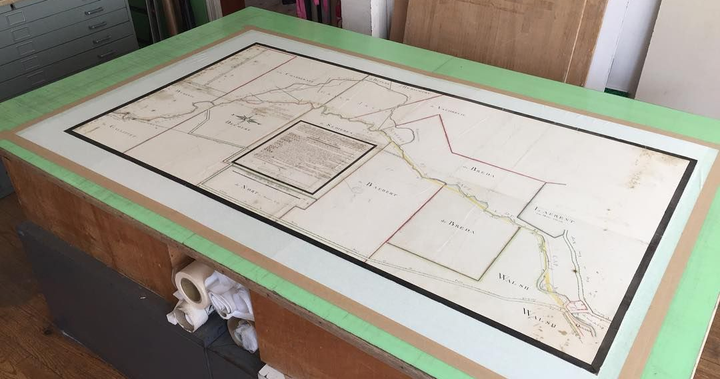 Grande carte sur table, encadrée d'une bordure vert clair.